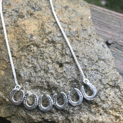 Horseshoe bar necklace. This is my take on the fashion statement necklace, except with horseshoes. Six small horseshoes in a row with a chain. As always, available in sterling and gold. You can customize with any gemstone.