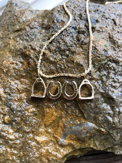 2 little horseshoes flanked by 2 English stirrups hung with 2 gold jump rings. This is one of my popular pendants and look lovely hanging from a golden chain. Chain not included