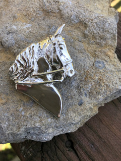 Saddlebred head pendant. A sculpture of one of my favorite horses, the gaited horse looking forward with ears forward. Bridle is one of the details to this lovely pendant. Available in sterling silver or gold with the option to add gemstones. This would also make a lovely lapel pin!