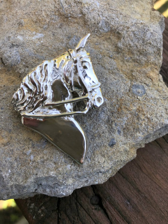 Saddlebred head pendant. A sculpture of one of my favorite horses, the gaited horse looking forward with ears forward. Bridle is one of the details to this lovely pendant. Available in sterling silver or gold with the option to add gemstones. This would also make a lovely lapel pin!