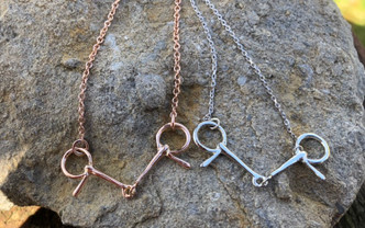 A half cheek bit is used in a harness to get the horse's head set up. This is connected to the overcheck on the harness. This necklace can be done in any gold you want and comes with a 16-inch chain. Please specify length of chain.