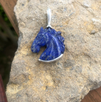 This blue lapis carved horse head is set in sterling silver with a bail. This has iron pyrite sprinkled throughout the stone. This pendant is the size of a quarter and would make a lovely lapel pin. This can also be set in 14K gold and paved with diamonds. The back of the silver is done in a lovely geometric design.