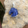 This blue lapis carved horse head is set in sterling silver with a bail. This has iron pyrite sprinkled throughout the stone. This pendant is the size of a quarter and would make a lovely lapel pin. This can also be set in 14K gold and paved with diamonds. The back of the silver is done in a lovely geometric design.