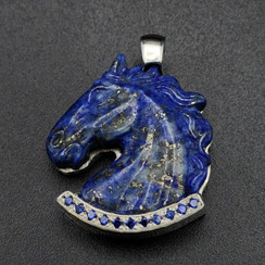 A Lapis carved horse head pendant that is paved with lab sapphires in the lower border to emphasis the blue in the stone. It is a very elegant piece set into geometric patterned sterling silver. This is a truly a very elegant piece with iron pyrite shimmering into the lapis.