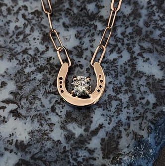 A dainty horseshoe necklace to be ordered in any gold but pictured in rose gold featuring a 4mm Cubic zirconium.  This chain features a 2mm paper clip chain. This necklace can be ordered in sterling silver, or yellow or white gold. It makes a perfect layering piece with other chain but is perfect to stand alone.