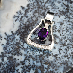 A western stirrup in sterling silver featuring a deep purple AAA amethyst in the middle. This piece has on the lower border of the stirrup a line of cz to give it that extra bling. A row or hearts line the side of this special stirrup.