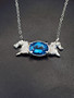 A sterling silver horse heads necklace with a oval Swiss blue topaz. The chain is 18-inches long. This makes a beautiful statement piece.