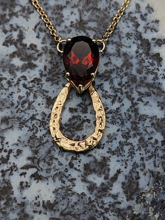 A beautiful 14k gold hammered horseshoe with a pear-shaped madeira citrine. The chain is 18-inches long. The citrine is an orange red gemstone and is AAA.