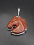 A beautiful carved red jasper horse head pendant. This horse is set in sterling silver with a beautiful geometric triangle pattern on the back of the silver. This pendant resembles a chestnut horse.  Call 8593330458 with any questions.
