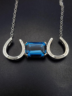 Elegant emerald cut London blue horseshoe necklace on a sterling silver with an 18-inch chain!! A lovely piece.