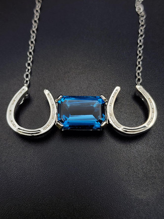 Elegant emerald cut London blue horseshoe necklace on a sterling silver with an 18-inch chain!! A lovely piece.