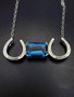 Elegant emerald cut London blue horseshoe necklace on a sterling silver with an 18-inch chain!! A lovely piece.