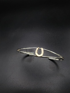 Yes we can mix our metals!! A 14k gold small horseshoe on a delicate but sturdy sterling silver bracelet. A essential for equestrian wardrobe!