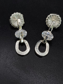 Delicate horseshoe earrings in door knocker fashion. Featuring czs in sterling silver with posts.
