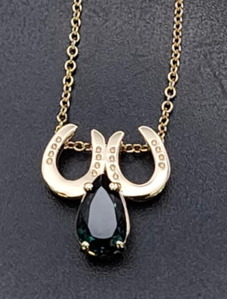 A stunning teal pear tourmaline with 2 14K yellow gold horseshoes. This is a pendant and can be worn with your gold chain or ours and is a very unique piece. You can order a chain if you wish call 8593330458 for help
