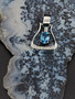 A western stirrup in sterling silver featuring a vibrant AAA Swiss blue topaz in the middle. This piece has on the lower border of the stirrup a line of cz to give it that extra bling. A row or hearts line the side of this special stirrup