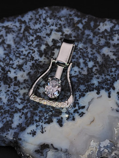 A stunning sterling silver western stirrup featuring a 8x6 cubic zirconium and on the bottom of the stirrup. This pendant has hearts going up the sides. Call to customize. 8593330458.