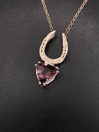 A special 14k rose gold hammered horseshoe featuring a lovely pink tourmaline necklace. The chain is 18 inches. This makes a lovely gift.