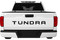 Rear tailgate of white Toyota Tundra truck showing black letter and text decals.