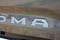 Rear tailgate of dark Toyota Tacoma truck showing silver letter and text decals.