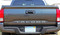 Rear tailgate of dark Toyota Tacoma truck showing silver letter and text decals.