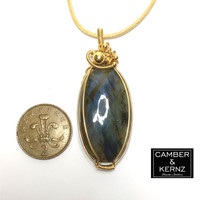 Size guide of Front view of oval Labradorite pendant necklace next to UK 2 pence coin. Coin measures approx 25.9mm diameter