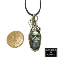 Size guide of carved Labradorite skull pendant next to UK 2 pence coin. Coin measures approx 25.9mm diameter