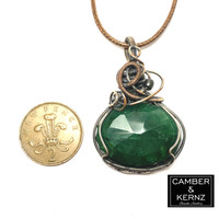 Size guide of green Emerald oval pendant necklace enhanced with dark grey hematite next to UK 2 pence coin. Coin measures approx 25.9 mm diameter