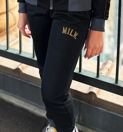 414 Black and Gold Track Womens Pant. Gold embroidery. Slim fit. Full zip with ribbed stand-up collar. 52% cotton, 48% recycled polyester doubleknit. Front zip pockets