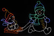 Two LED snowmen adorn in colorful hats, scarves and mittens; one snowman is pulling the other on a red sleigh