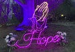 A yard with light displays of the word "hope" and praying hands.