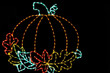 LED light display of a beautiful orange pumpkin with a green stem surrounded by colorful leaves