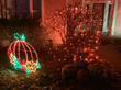 Vibrant pumpkin light display in a yard.
