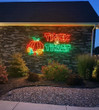 Vibrant pumpkin light display on a house.
