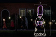 White and purple LED light display of the bride of Frankenstein holding a spider with dimensions 3' by 7'3"