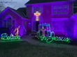 A house with light signs saying "believe in Jesus" in the yard.