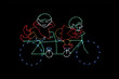 Light display of elves on a bicycle.