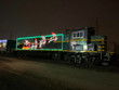 A light display of santa and his reindeer, showcased on a train.