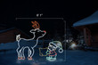 LED animated light display of a green, red and white elf feeding a white and red reindeer with dimensions 6'1" by 6'1"