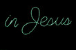An LED light Christmas wireframe decoration reading "in Jesus" in green script. 