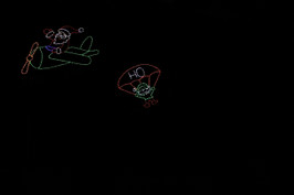 An LED light animated Christmas decoration depicting Santa in an airplane deploying an elf in a parachute.