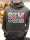 Black hooded XXL sweatshirt with screened SSM logo. 60/40 ring-spun cotton/polyester, 2 ply hood, spandex reinforced rib knit cuffs and waistband.  Pouch pocket with headset opening