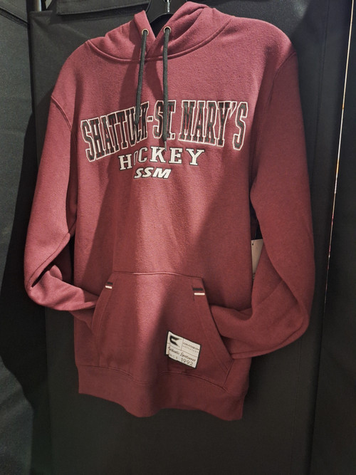 Maroon hockey hoodie featuring Shattuck-St. Mary's Hockey SSM embroidered in black and white lettering on the front. Drawstring hood with cuffed sleeves and waist. 70% cotton/30% polyester. Men's sizes small, medium, large and X-large.