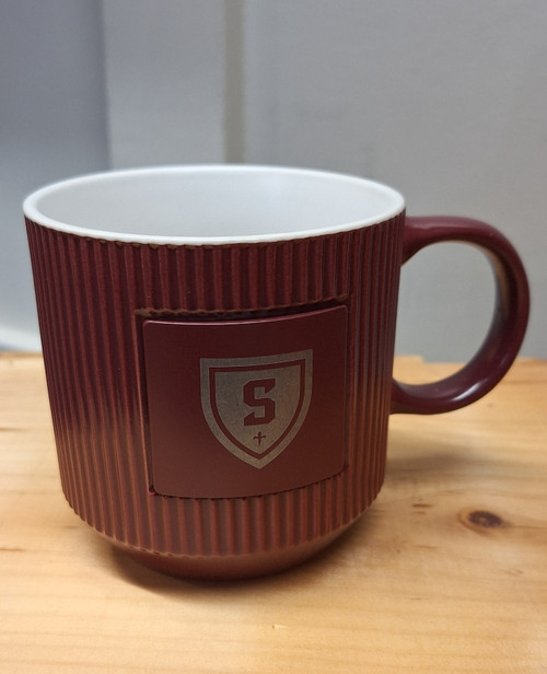 Maroon ceramic mug featuring metal plate with laser engraved shield logo. Hand wash only - Do not microwave.