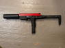 The VORSK VMP-1X SMG Gas BlowBack Semi Auto Only SMG in Black/Red shown from the left on a textured surface. The VORSK VMP-1X SMG Gas BlowBack Semi Auto Only SMG in Black/Red shown from the left on a textured surface.