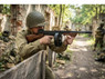 Player in WWII uniform aiming the Cybergun Thompson M1928 "Chicago Typewriter" AEG Airsoft Rifle in Wood at a skirmish. Player in WWII uniform aiming the Cybergun Thompson M1928 "Chicago Typewriter" AEG Airsoft Rifle in Wood at a skirmish.