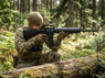 Cyma CM009A3 Metal Body M16A3 AEG Airsoft Rifle in Black aimed by a kneeling player behind a fallen log Cyma CM009A3 Metal Body M16A3 AEG Airsoft Rifle in Black aimed by a kneeling player behind a fallen log