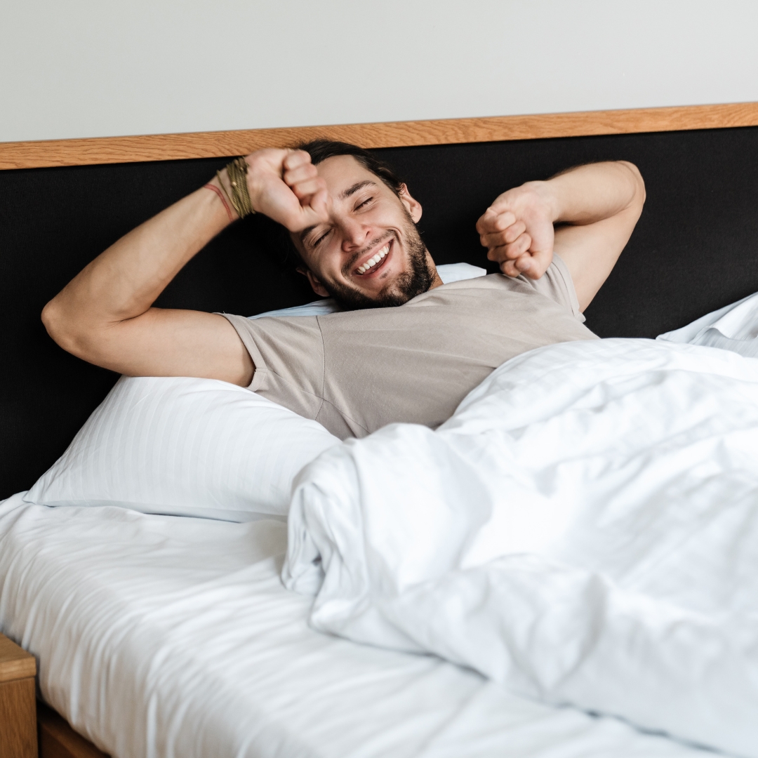 Man smiling after getting a good night sleep