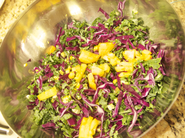 kale and red cabbage in a mixing bowl with corn kernels