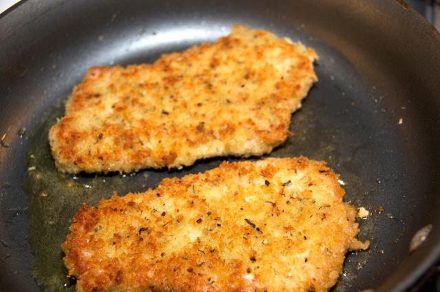 fried pork loin crusted with panko breadcrumbs in frying pan